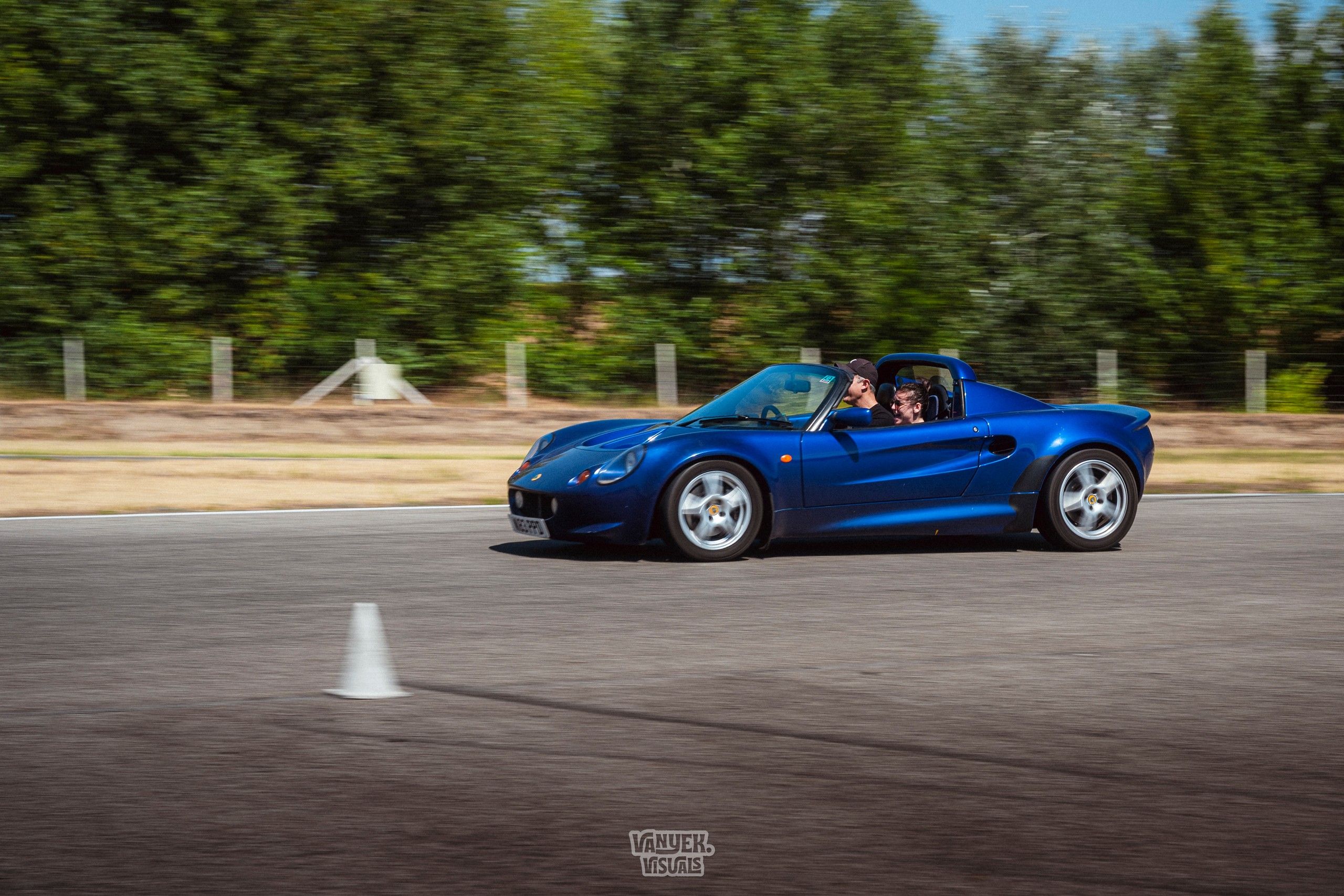 Kék Lotus Elise nagy sebességgel halad a versenypályán